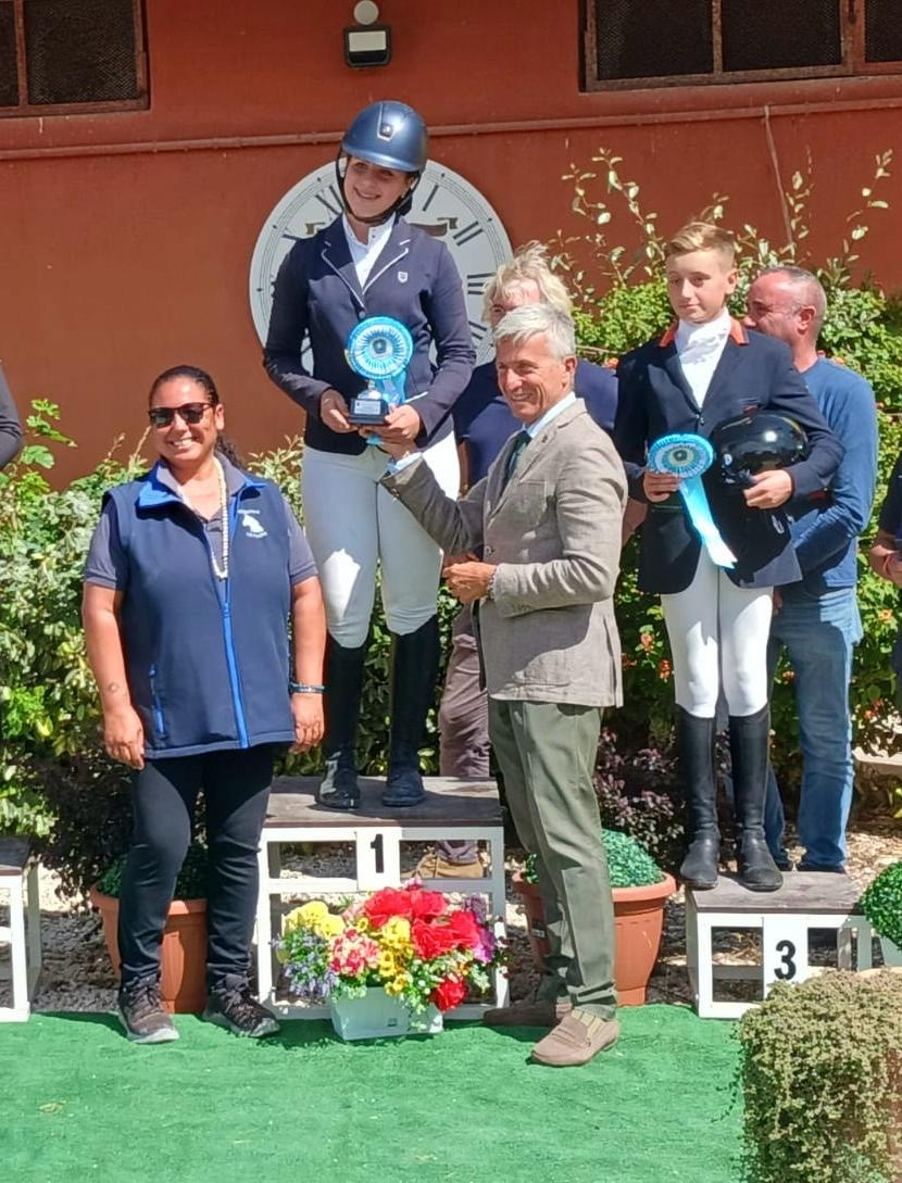 Premiazione con coccarde azzurre durante concorso ippico