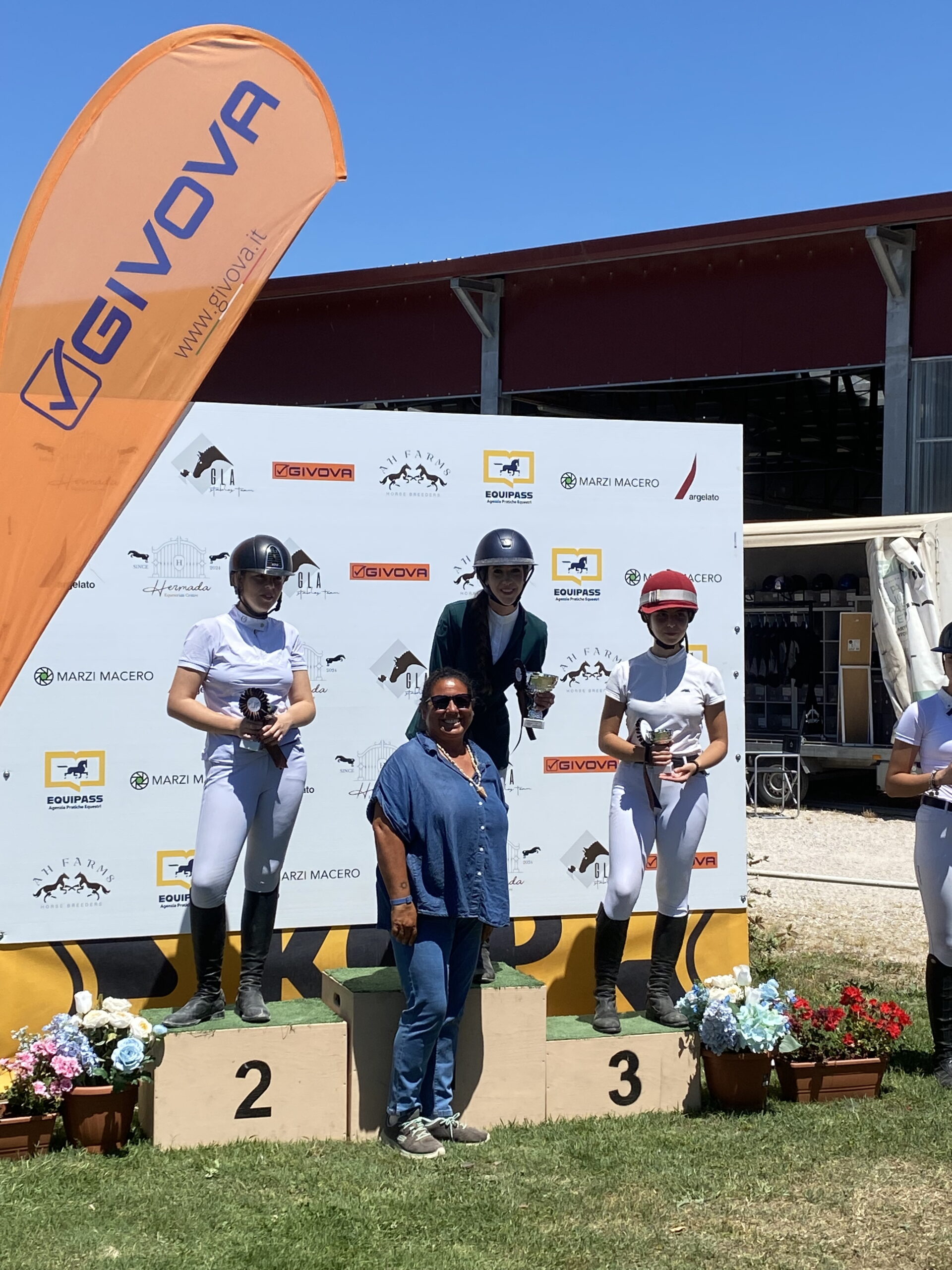 Podio di gara di salto ostacoli con giovani cavalieri premiati
