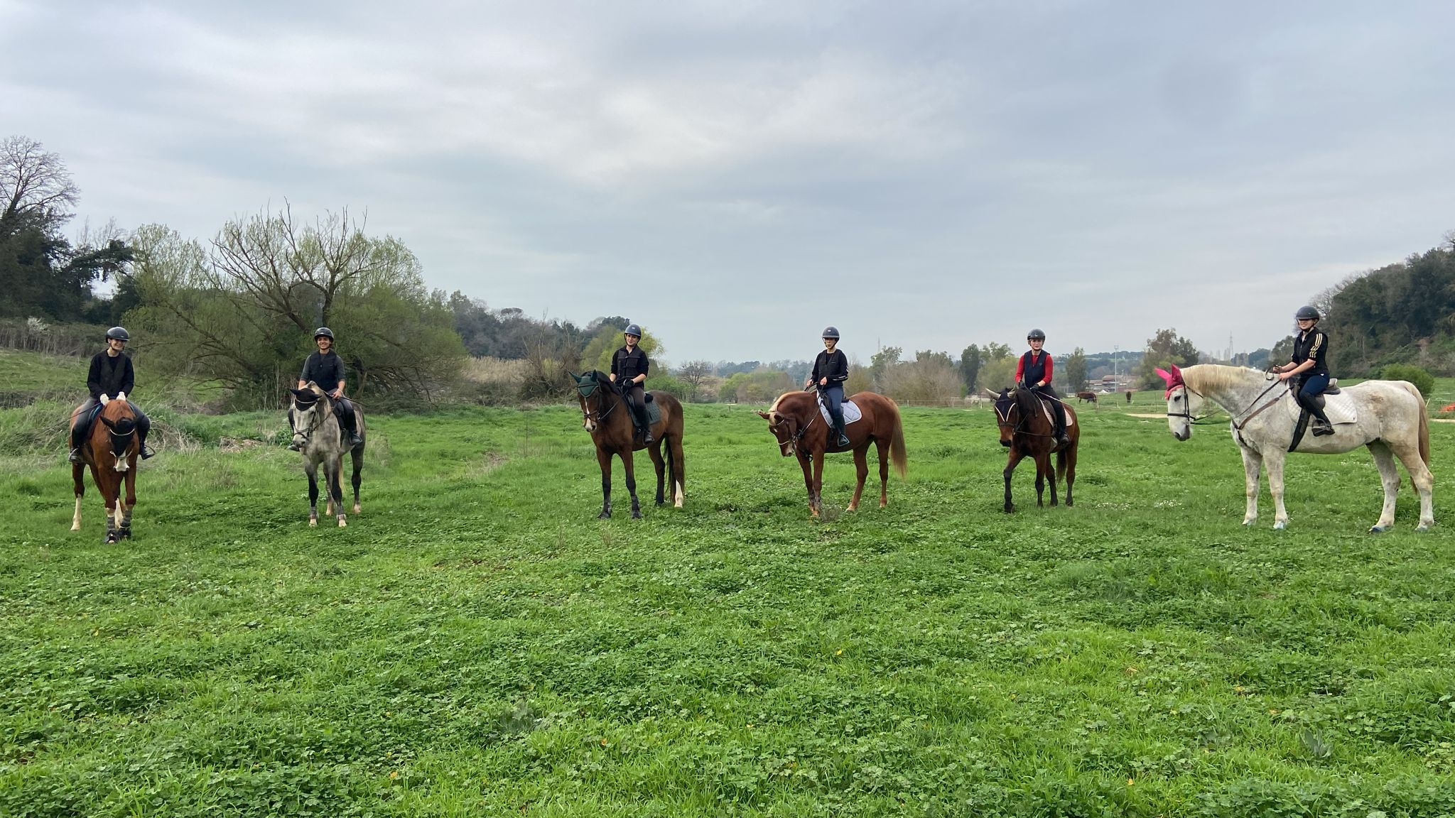 Cavalieri a cavallo durante una lezione di equitazione all’aperto nel centro ippico