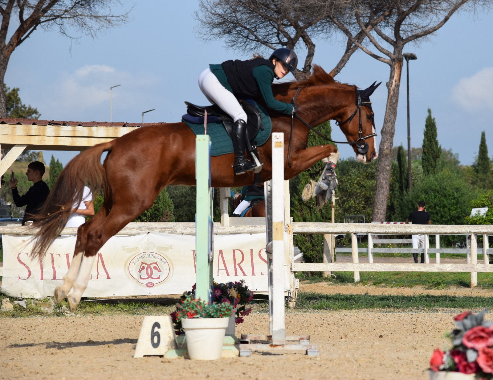 Cavallo e amazzone in salto su ostacolo alto durante gara